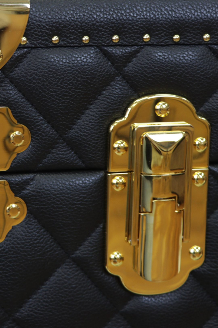 Kofferschrank aus gestepptem Leder mit Messingbeschlägen